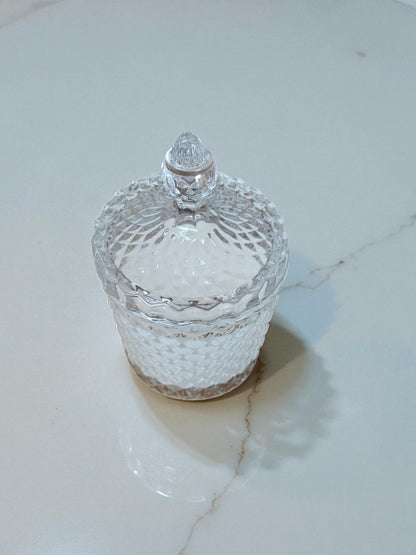 Vela artesanal de doble pabilo elaborada con 340 gramos de cera de soja pura, presentada en elegante vaso de cristal con tapa. La cera de soja garantiza una combustión limpia y prolongada, liberando fragancias de manera uniforme.