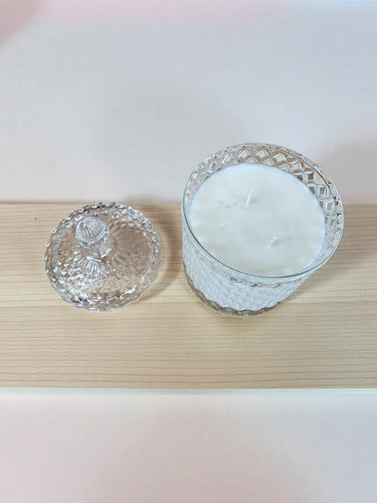 Vela artesanal de doble pabilo elaborada con 340 gramos de cera de soja pura, presentada en elegante vaso de cristal con tapa. La cera de soja garantiza una combustión limpia y prolongada, liberando fragancias de manera uniforme.
